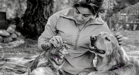 Woman petting a cat and a dog