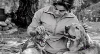 Woman petting a cat and a dog